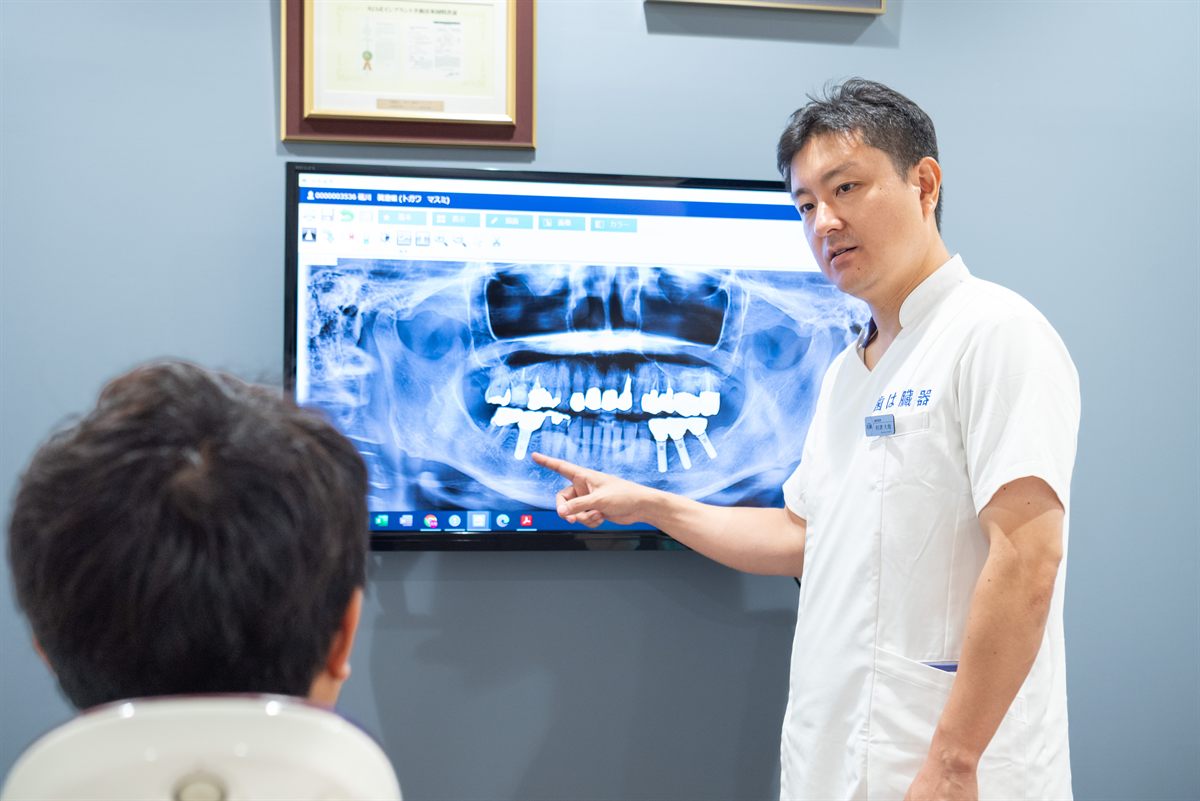レントゲン画像を見ながら理事長が患者様に説明している様子