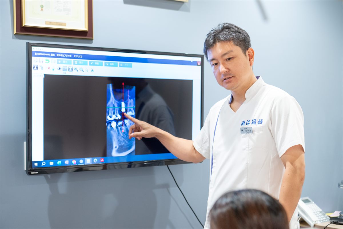 大型モニターでレントゲン画像を示す理事長