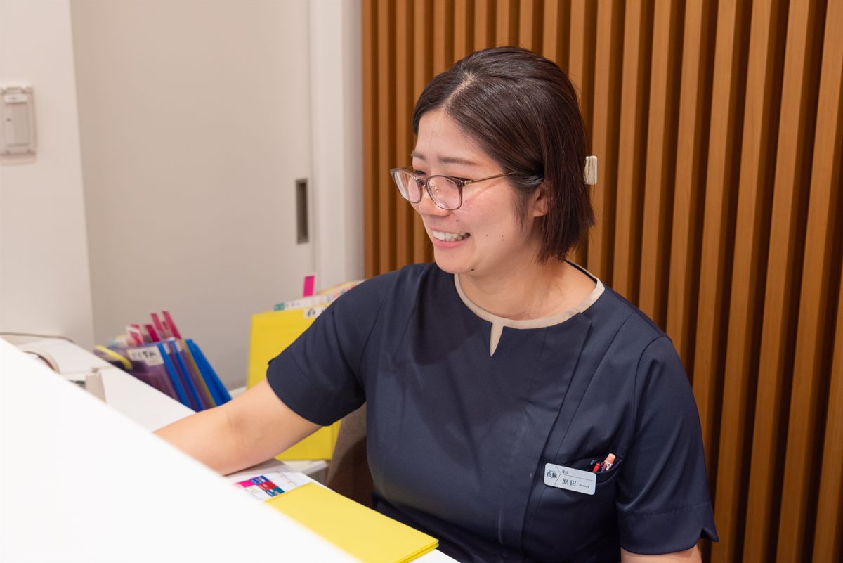 受付スタッフが笑顔で対応している様子