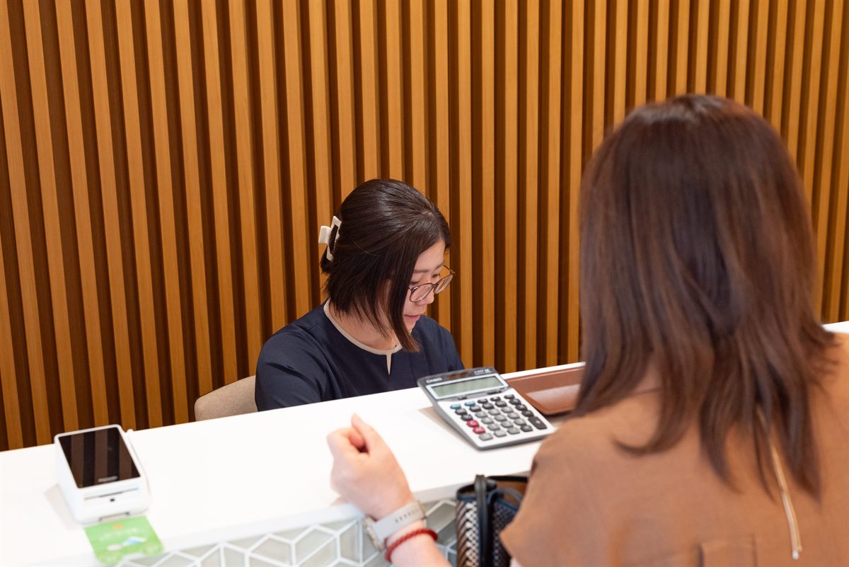 受付でスタッフが患者様にご案内している様子